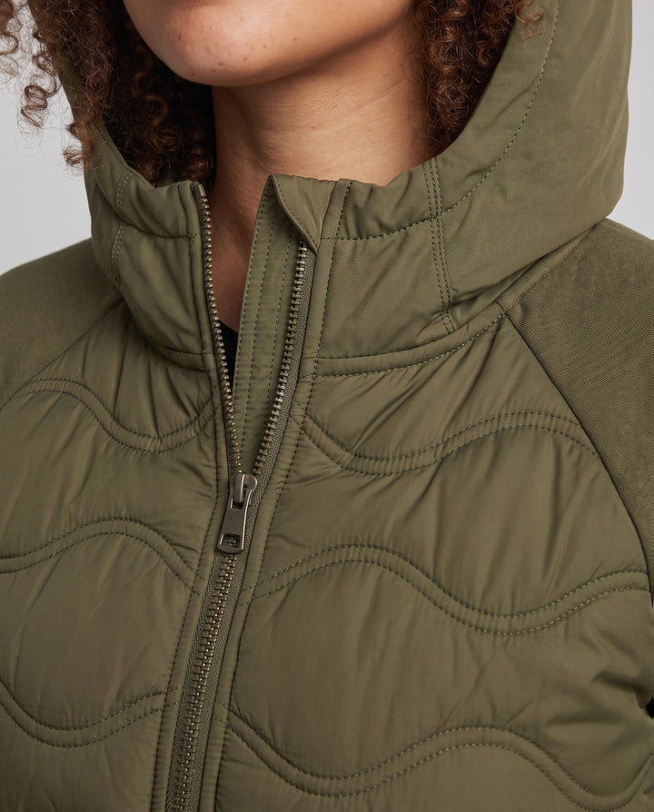 Women's quilted hybrid hoodie jacket with fleece sleeves, elastic cuffs, and wave quilting