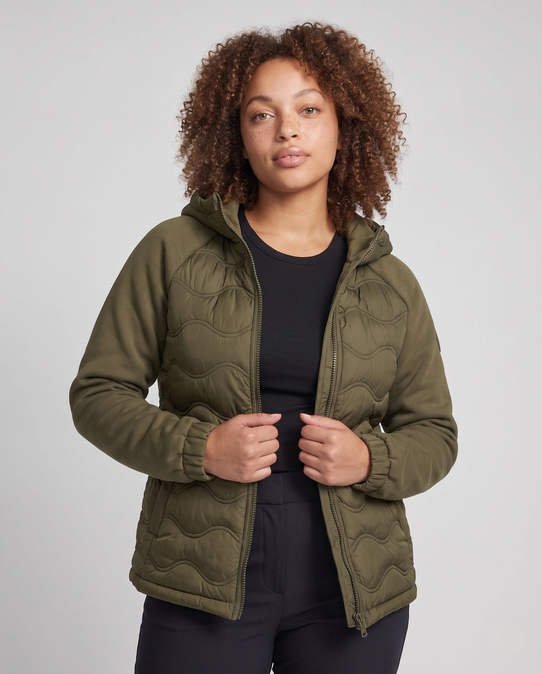Women's quilted hybrid hoodie jacket with fleece sleeves, elastic cuffs, and wave quilting