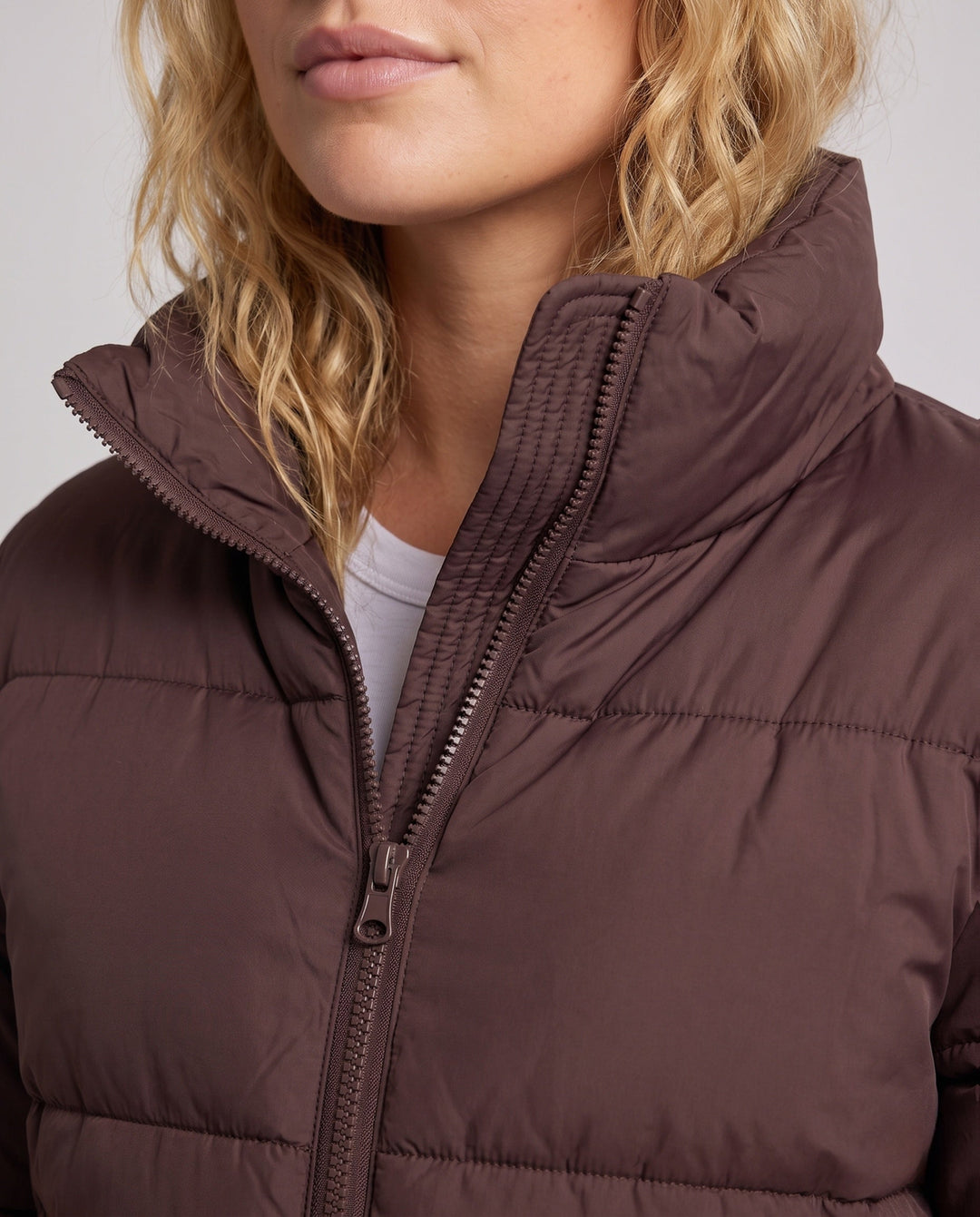Women's ultra-lightweight hoodless oversized puffer with high standing collar, silent outer shell, and thermally insulating padding