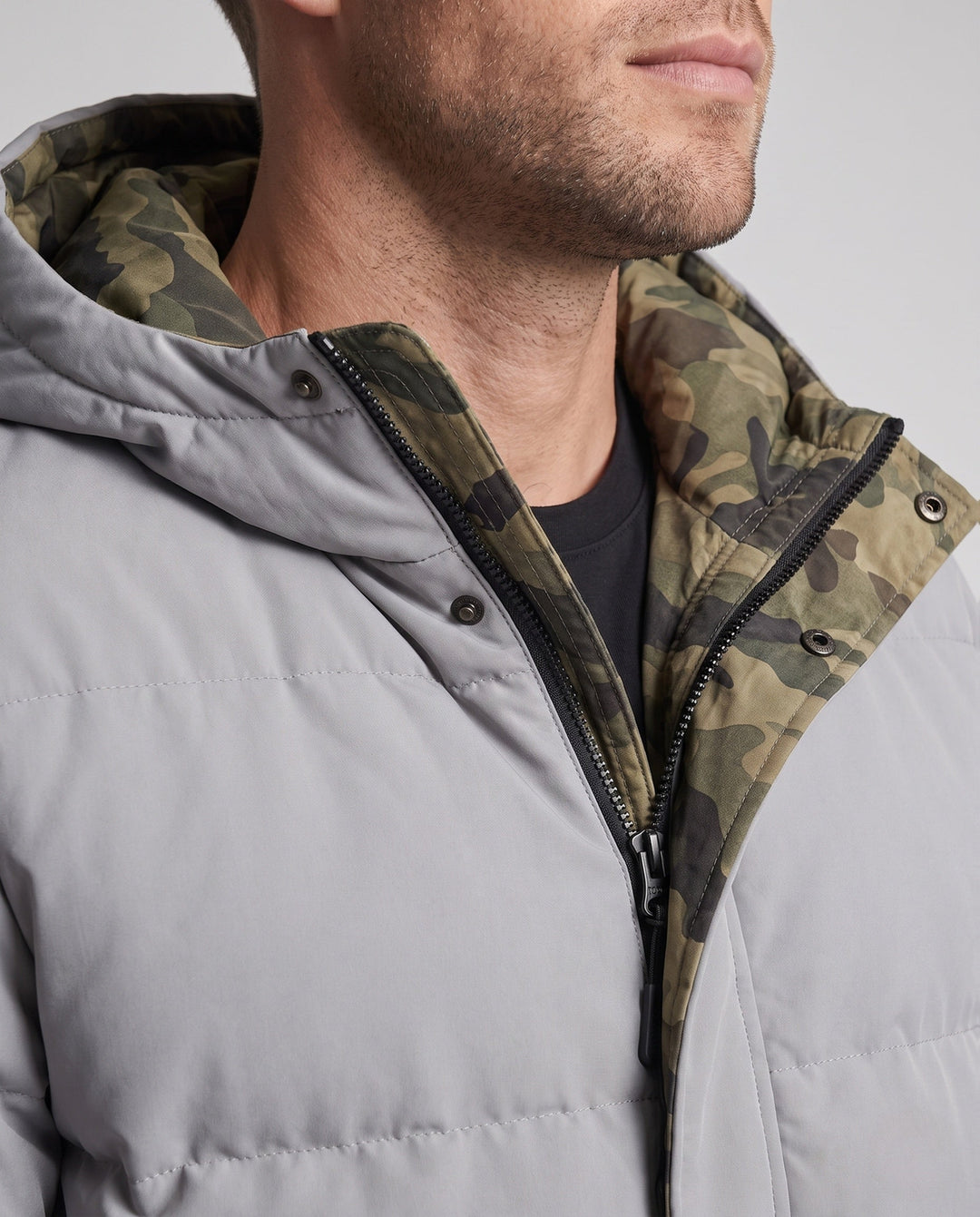 Men's short thermal quilted parka with hood, applied flap pockets, concealed front placket, and camouflage-lined interior