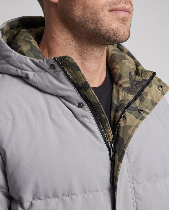 Men's short thermal quilted parka with hood, applied flap pockets, concealed front placket, and camouflage-lined interior