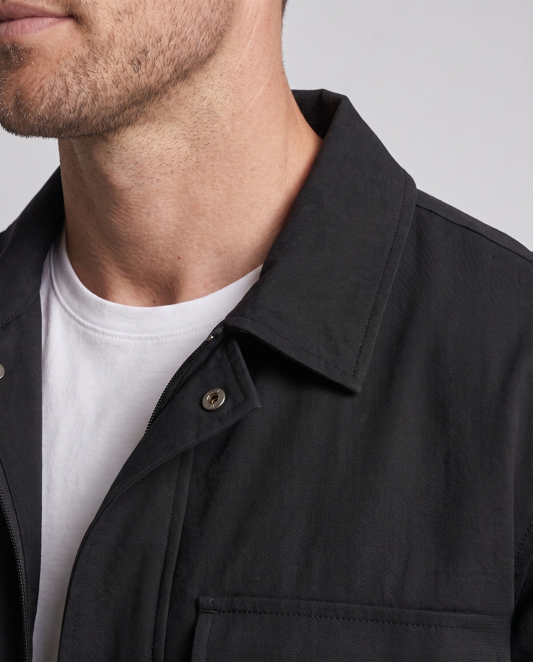 Men's casual field jacket with chest flap pockets, elastic hem, and zipper