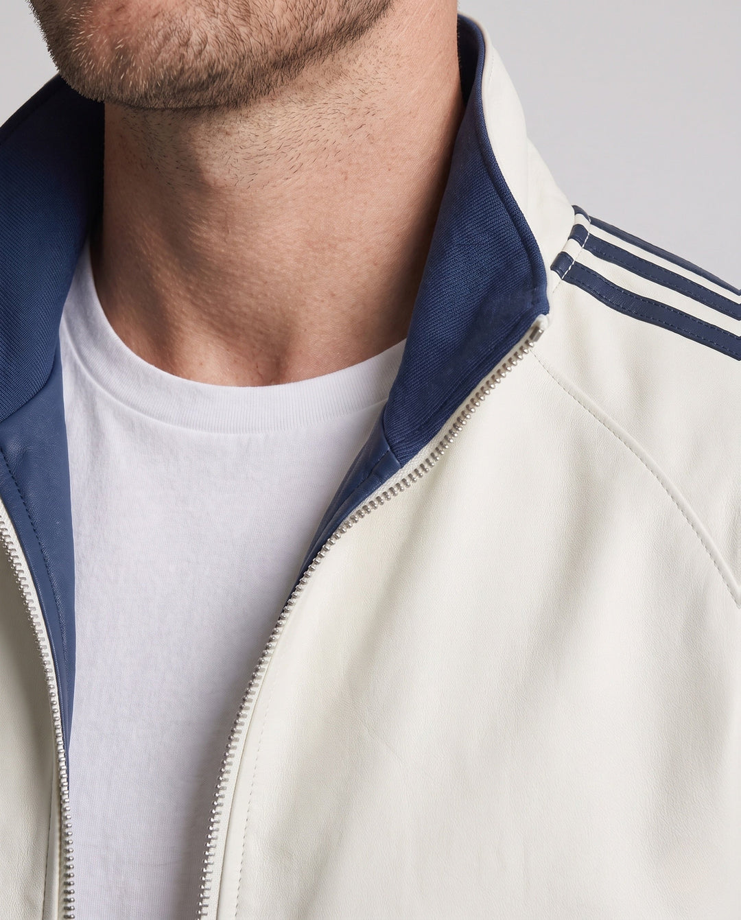 Unisex reversible sports jacket with reversible design, stand-up collar, full-length zipper, and distinctive sleeve stripes